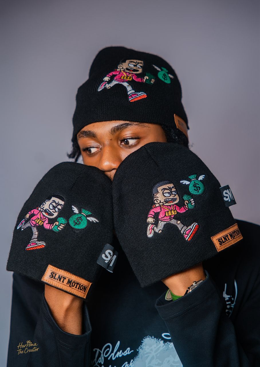 SLNT MOTION model holding two beanies up close to the face